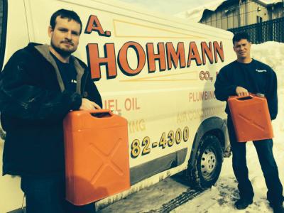 Phil McIntyre and Teddy Hohmann of A. Hohmann Co. hold up the five gallon GI cans that have become essential to getting emergency fuel deliveries to customers whose fill pipes are too deeply buried in snow.   		  	Bill Forry photo